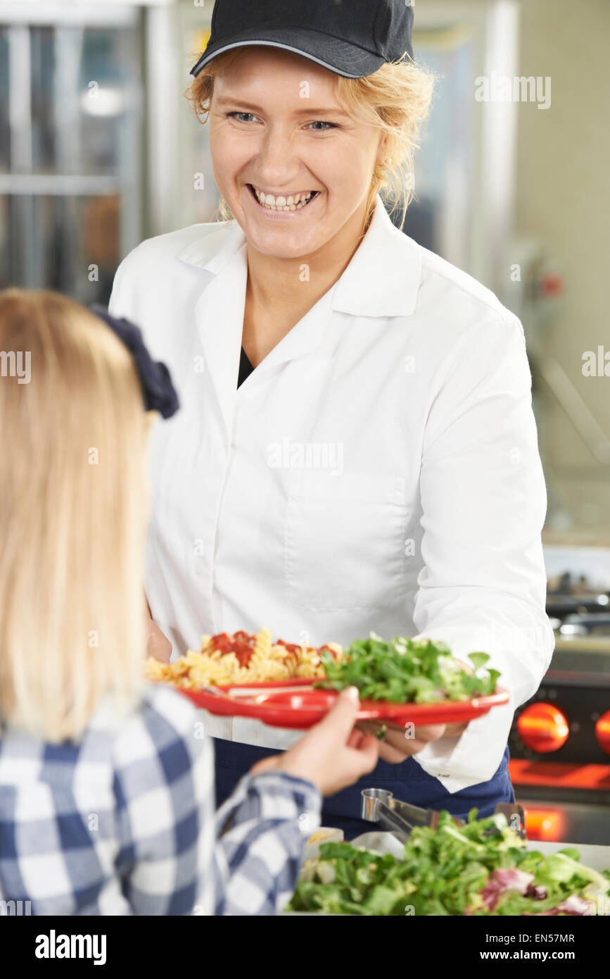 Pupil In School Cafeteria Being Served Lunch By Dinner Lady Stock Photo