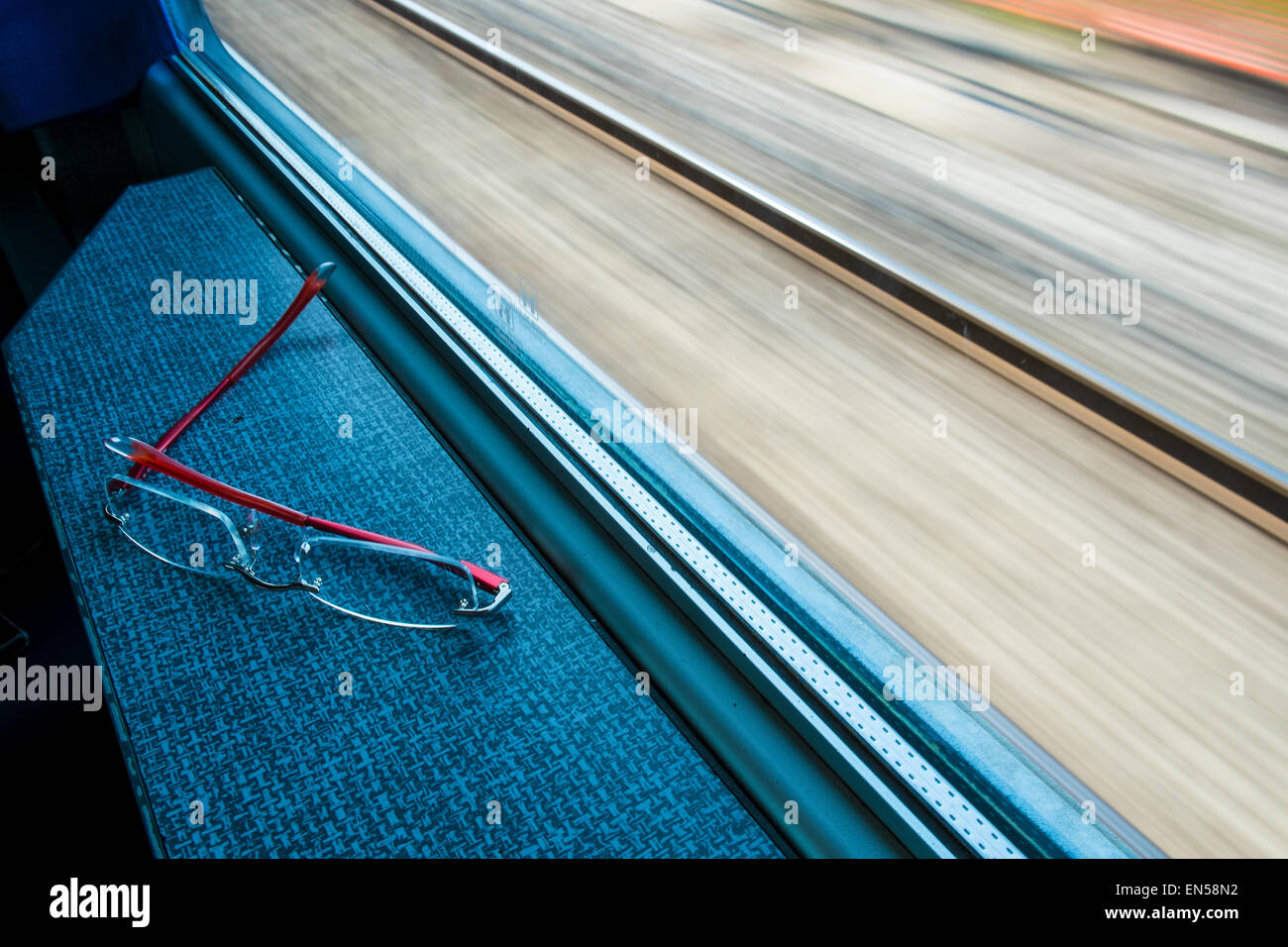 a pair of glasses in front of the train window Stock Photo