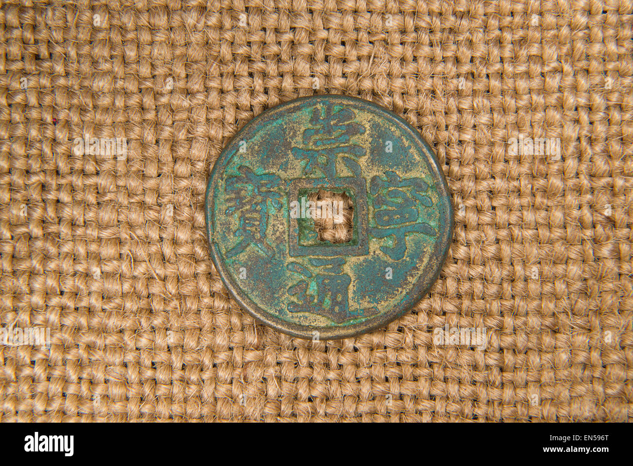 antique bronze Chinese coin on old cloth Stock Photo