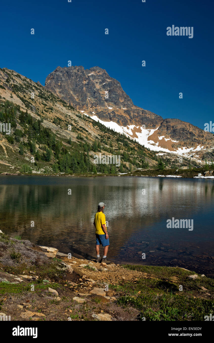 WASHINGTON - Hiker at Upper Snowy Lake with Tower Mountain beyond in the North Cascades section of the Okanogan National Forest. Stock Photo