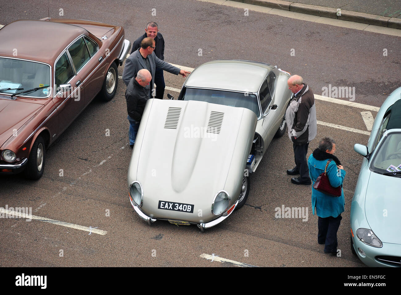 A silver E-type Jaguar with its bonnet open parked along Madeira Drive in Brighton for a car show. Stock Photo