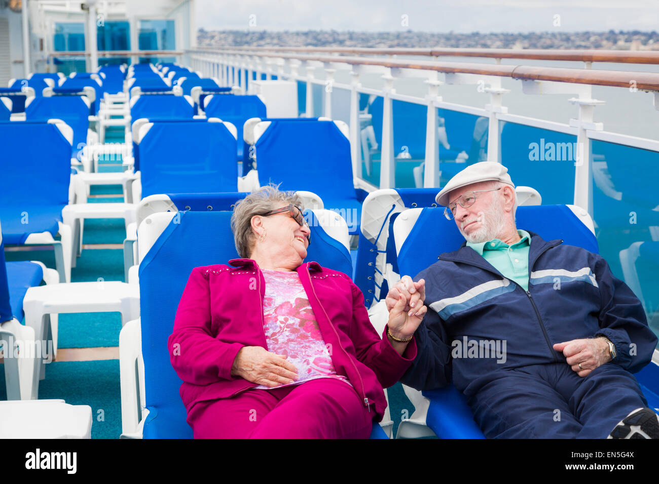 Happy Senior Couple Relaxing On The Deck of a Luxury Passenger Cruise Ship. Stock Photo