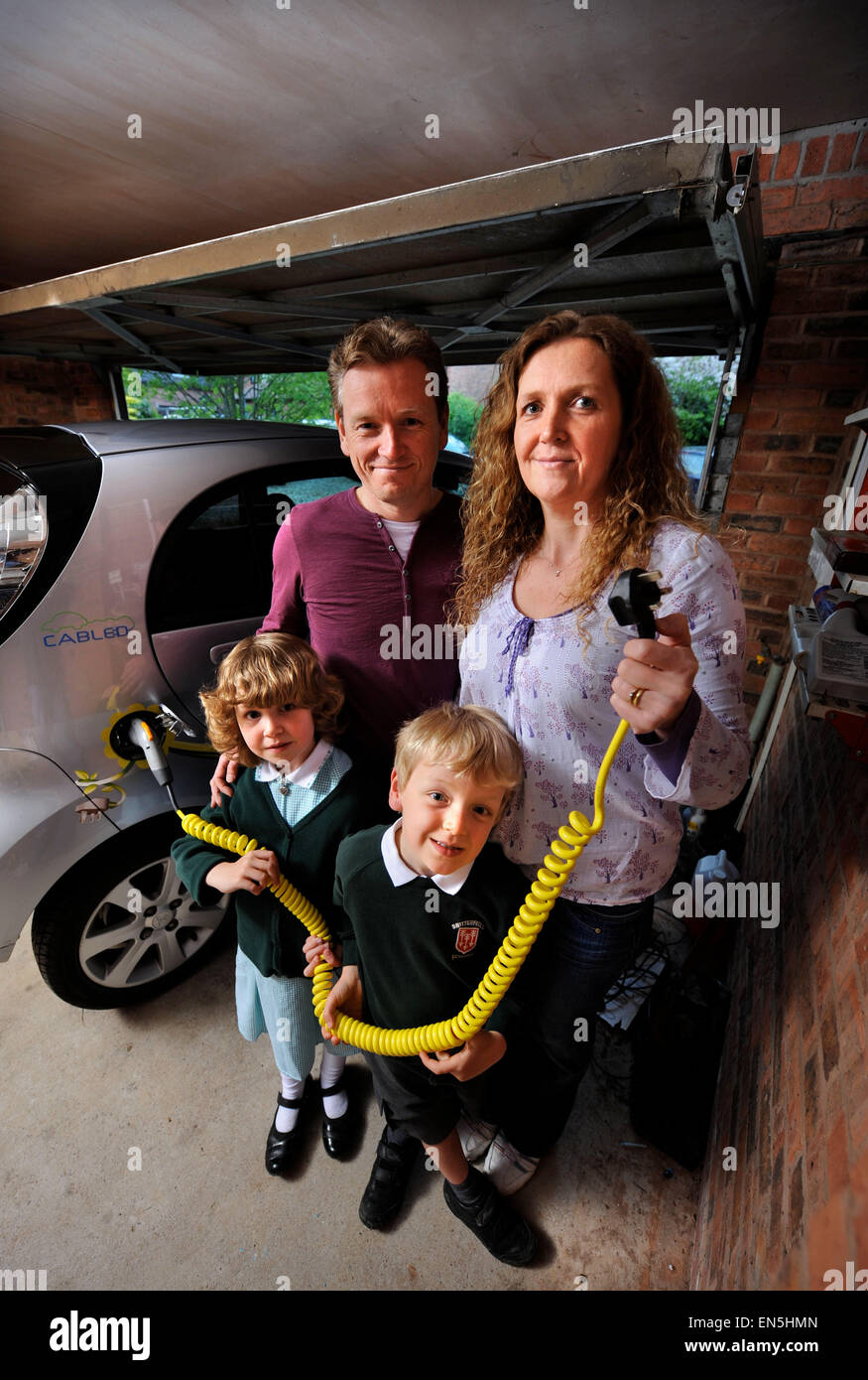 Plugging in an electric powered car at a family home in a garage UK