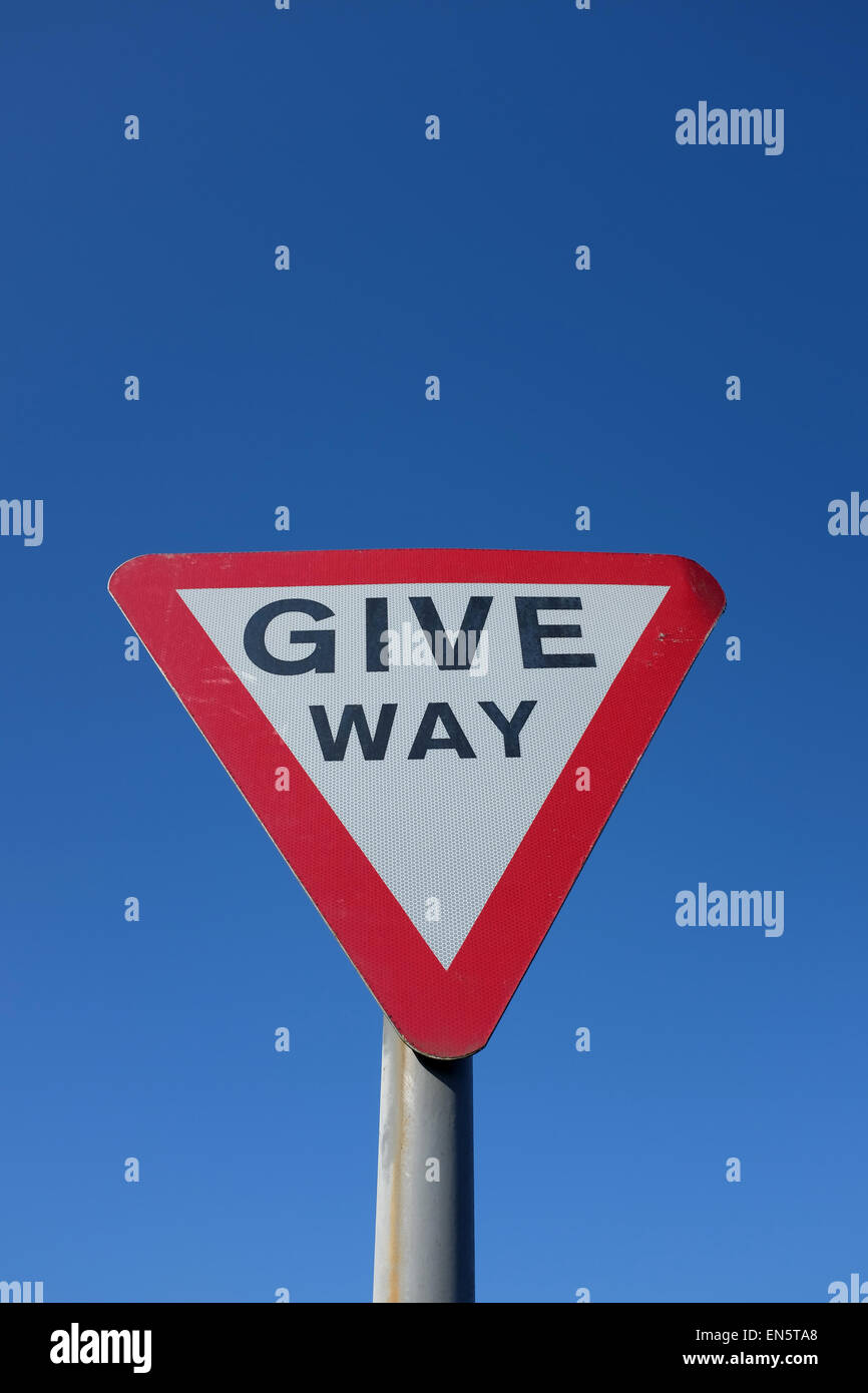 Give Way road sign against a blue background UK Stock Photo