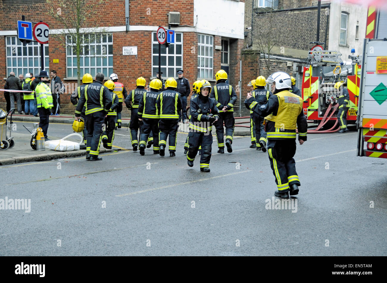 Male and female fire officers at the junction of Rollit Street and Hornsey Road, Holloway, North London after a fire broke out i Stock Photo