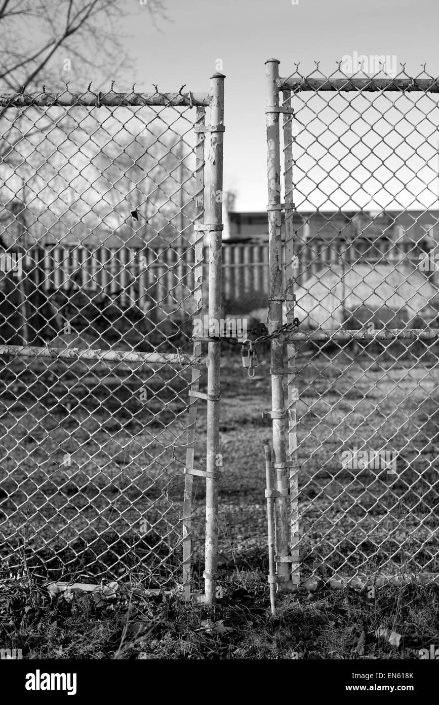 Abandoned factory gate padlocked in black and white Stock Photo