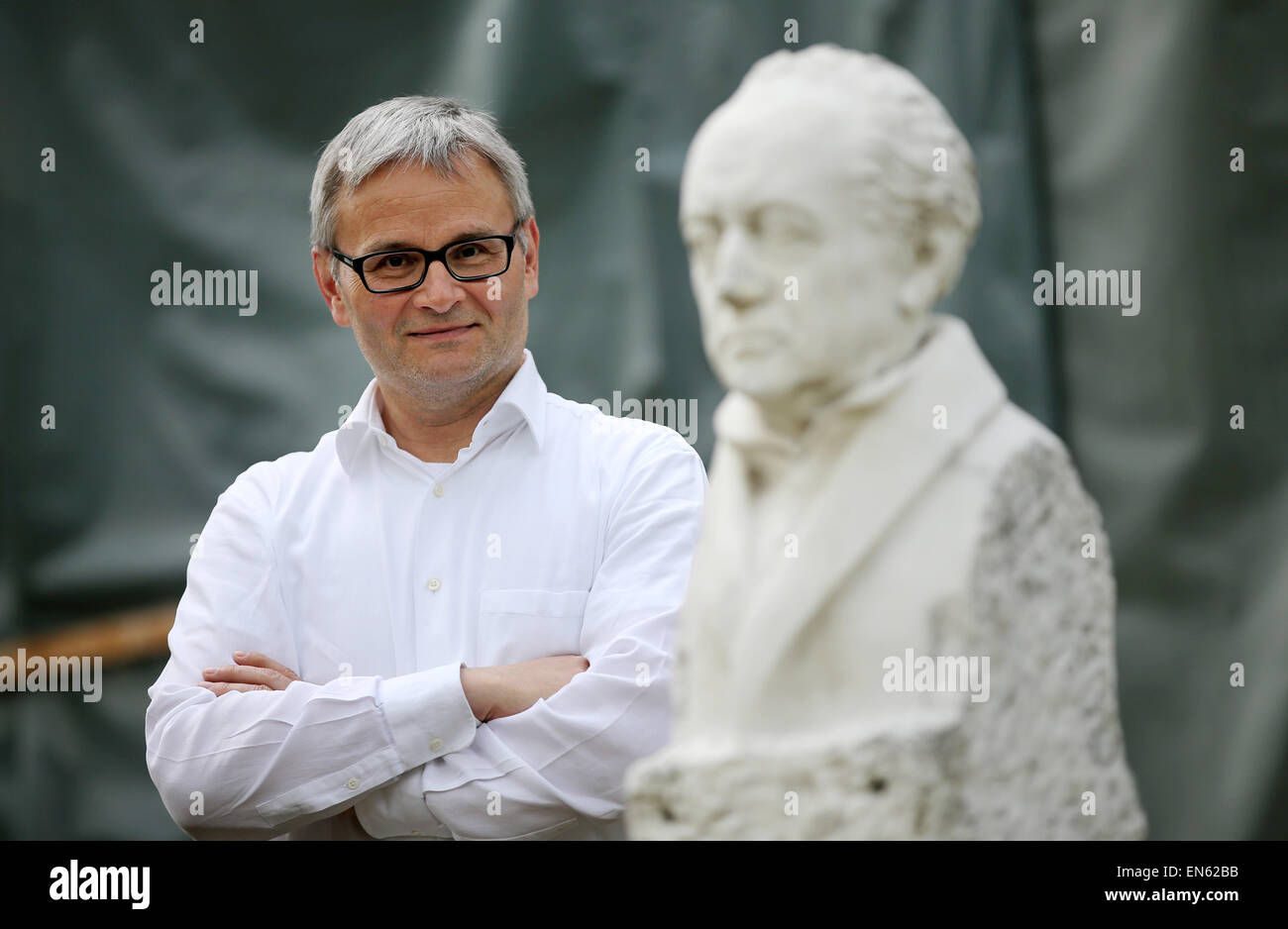 Bad Lauchstaedt, Germany. 28th Apr, 2015. Rene Schmidt, director of the historical cure facilities and of the Goethe theatre poses behind a bust of Goethe at the theatre in Bad Lauchstaedt, Germany, 28 April 2015. The venue that was designed and opened by Johann Wolfgang von Goethe more than 200 years ago is in need of redevelopment. The truss is affected by strong pest infestation including wet rottenness fungis and serpula lacrymans fungis. The renovation of the venue is to start from May during the running theatre business. Photo: Jan Woitas/dpa/Alamy Live News Stock Photo