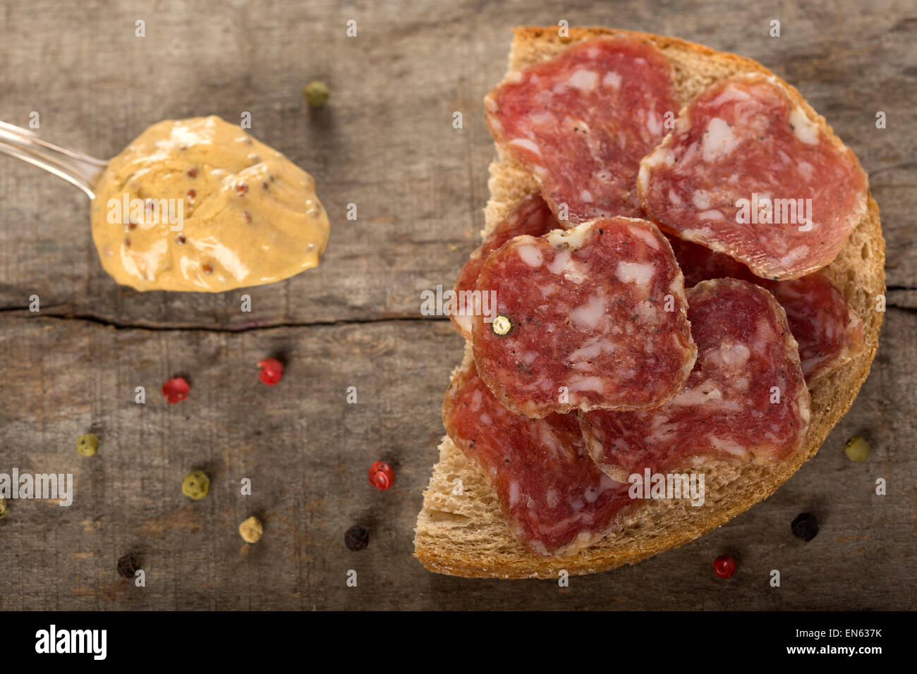 Open sandwich of salami slices on whole grain bread and spoon with