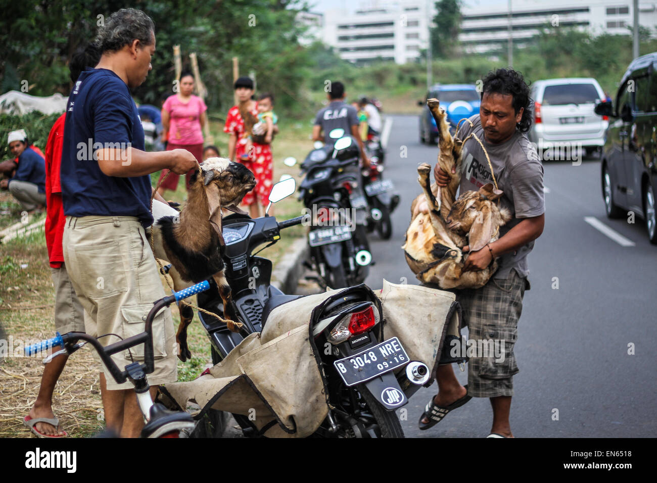 Tangerang, Indonesia. 28th Sep, 2014. A man carries home a small goat after Eid al-Adha prayers at Asmaul Husna Masjid. Eid al-Adha, also known as the Feast of Sacrifice, commemorates prophet Abraham's willingness to sacrifice his son as an act of obedience to God, who in accordance with tradition then provided a lamb in the boy's place. © Garry Andrew Lotulung/Pacific Press/Alamy Live News Stock Photo