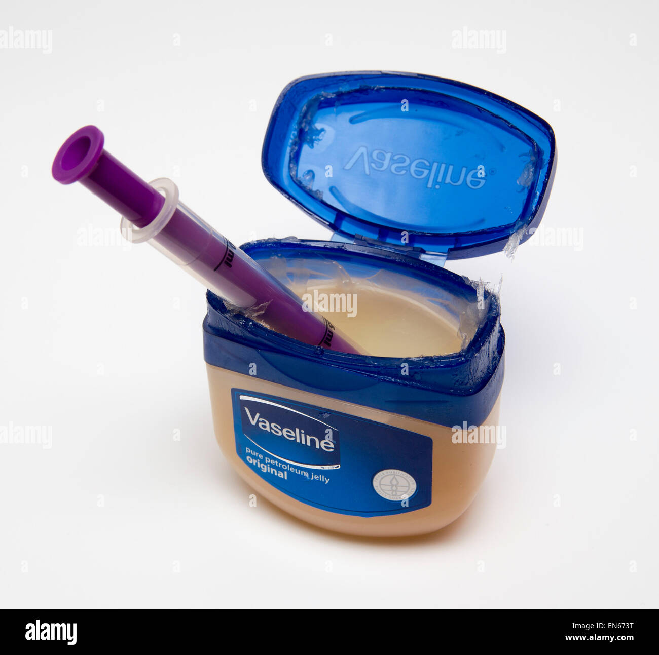 tub of Vaseline petroleum jelly containing a syringe, isolated on white background. Stock Photo