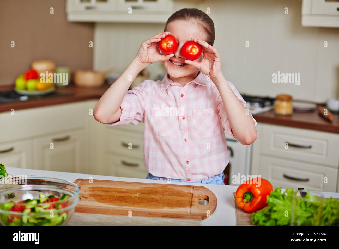 Smiling girl holding fresh tomatoes by her eyes Stock Photo - Alamy