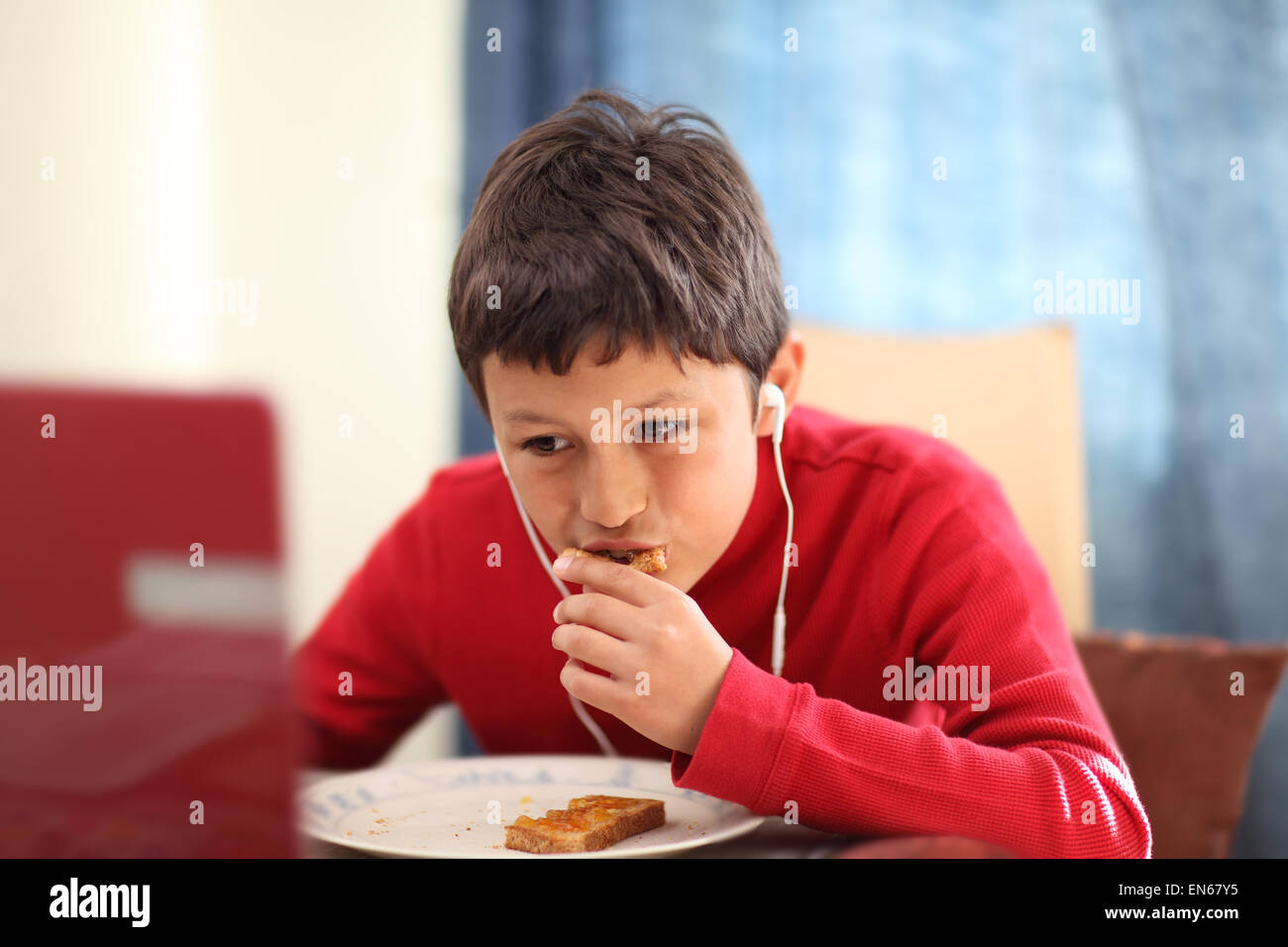 Young boy eating breakfast toast - shallow depth of field Stock Photo