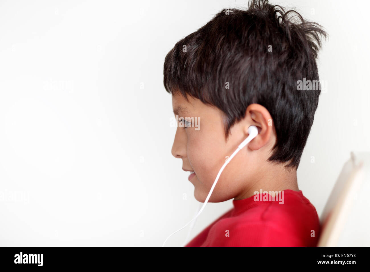Profile of young boy with earphones on light background Stock Photo