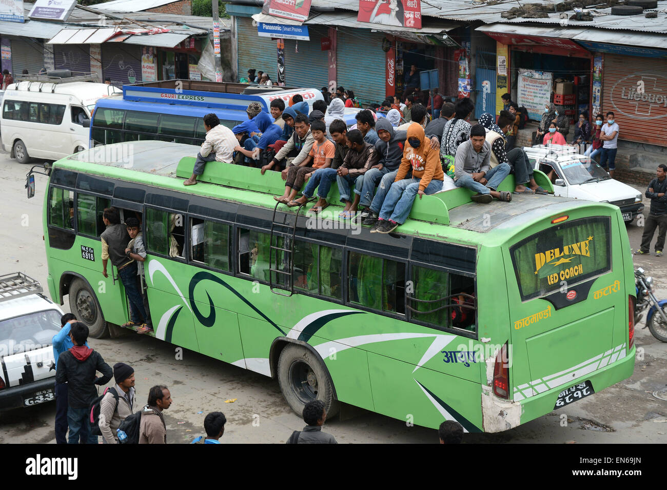 People travel unsafely on the roof of public bus at Kalanki Chowk in Kathmandu, Nepal, 28 April 2015. Thousands of people are flocking to Kathmandu's exit points to leave the city. A sheer number of people fleeing danger zones or looking for relatives is pushing the national transportation infrastructure to its limits. The highway remains clogged in many areas, officials said, with very limited food and water available at highway stalls. Photo: Subel Bhandari dpa (zu dpa-Korr '«Erdbeben mit Hunderttausenden Flüchtlingen überfordert Nepal' vom 28.04.2015) Stock Photo