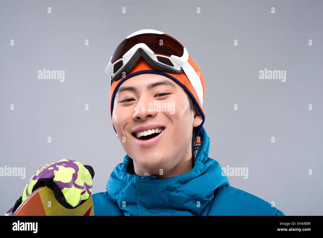 Portrait of a young man holding a snowboard looking at camera Stock ...