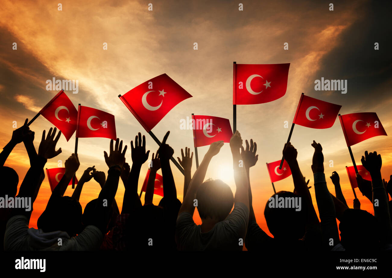 Silhouettes of People Holding the Flag of Turkey Stock Photo