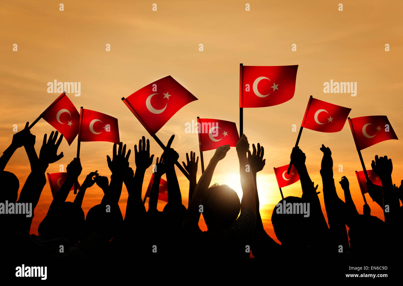 Silhouettes of People Holding the Flag of Turkey Stock Photo