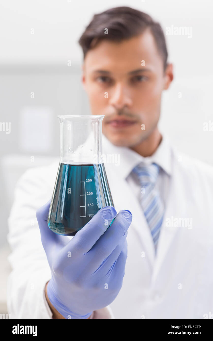 Concentrated scientist looking at beaker Stock Photo