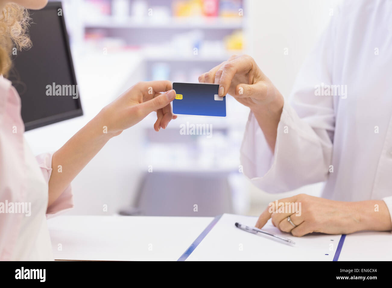 Pharmacist giving credit card to costumer Stock Photo