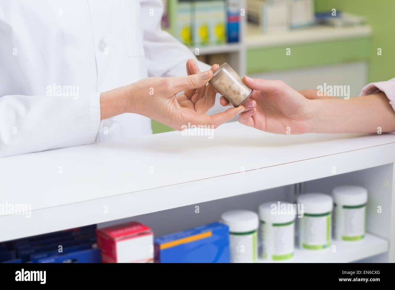 Pharmacist and costumer holding medicine jar Stock Photo