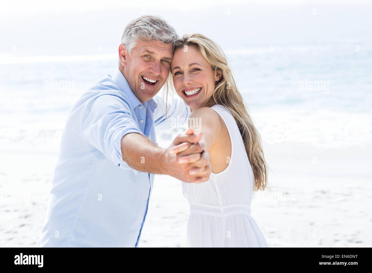 Happy couple holding hands and smiling at camera Stock Photo - Alamy