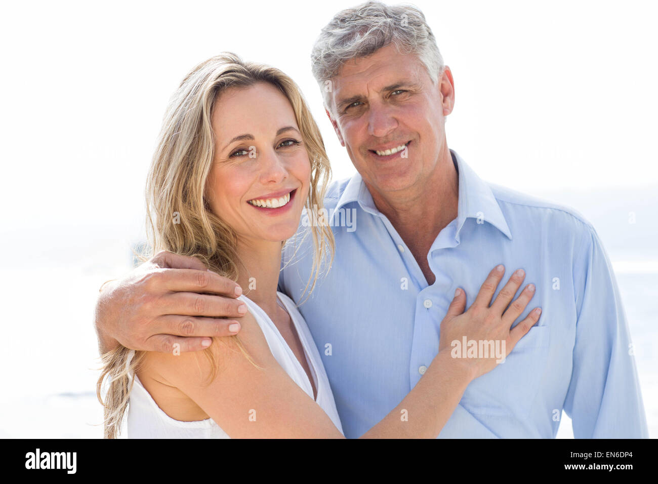 Happy couple standing by the sea and smiling at camera Stock Photo - Alamy