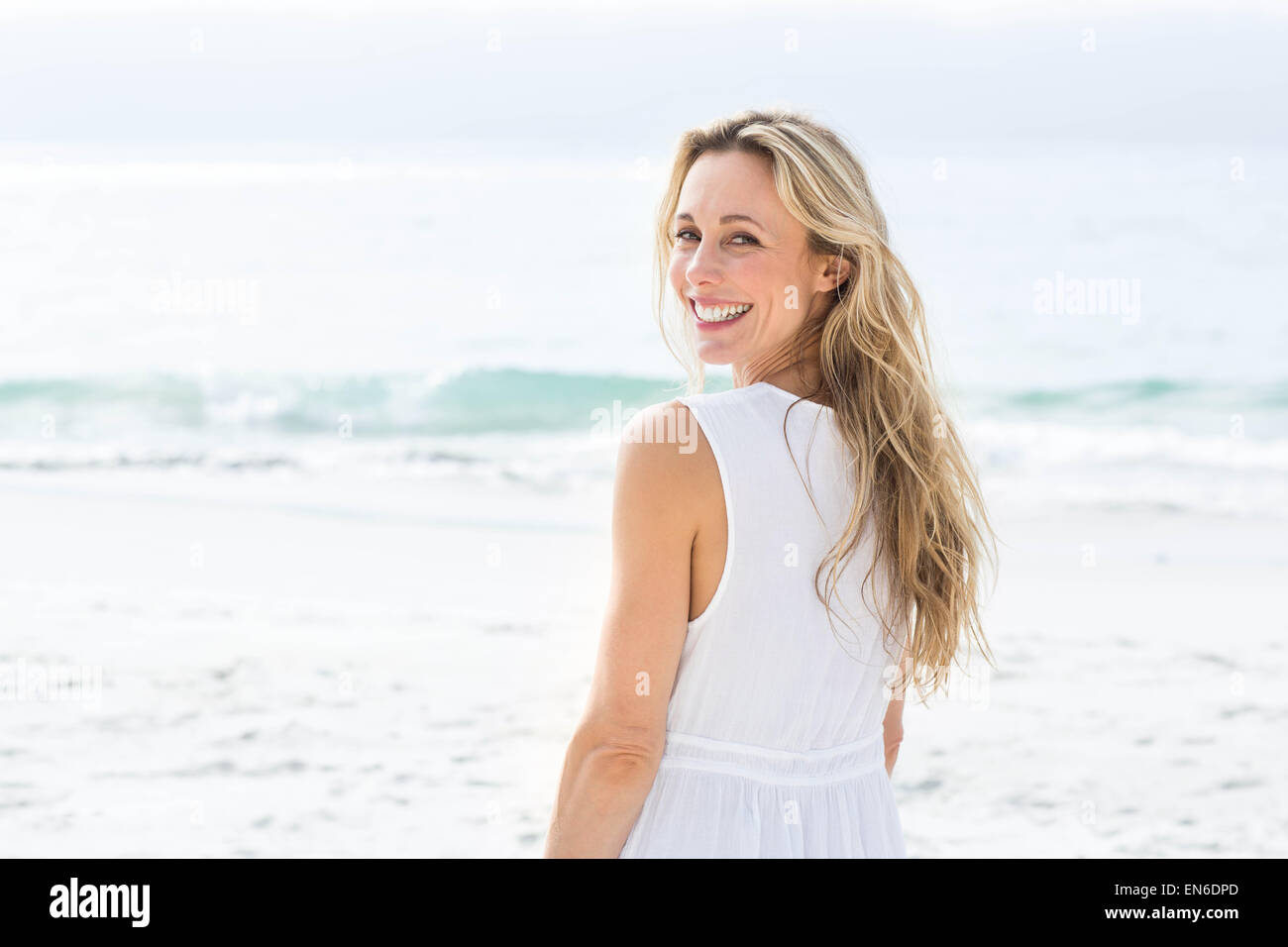 Smiling blonde in white dress looking at camera Stock Photo - Alamy