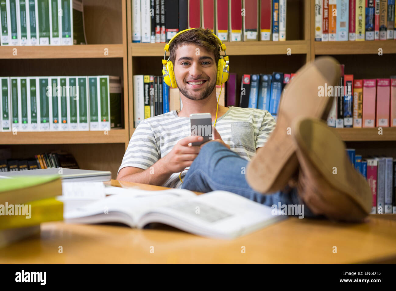 Student listening music in the library with smartphone Stock Photo - Alamy