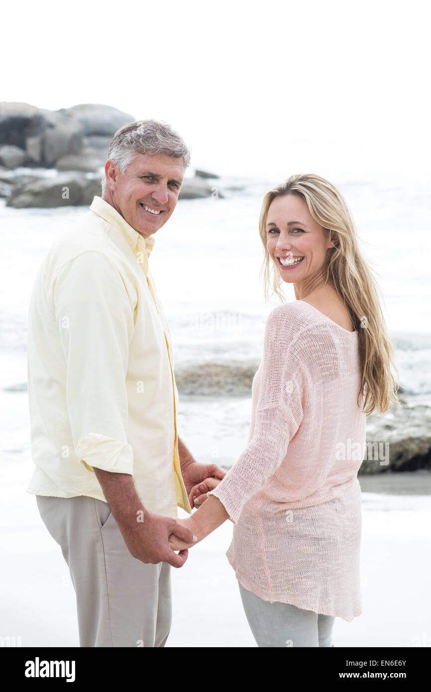Happy couple holding hands and smiling at camera Stock Photo - Alamy