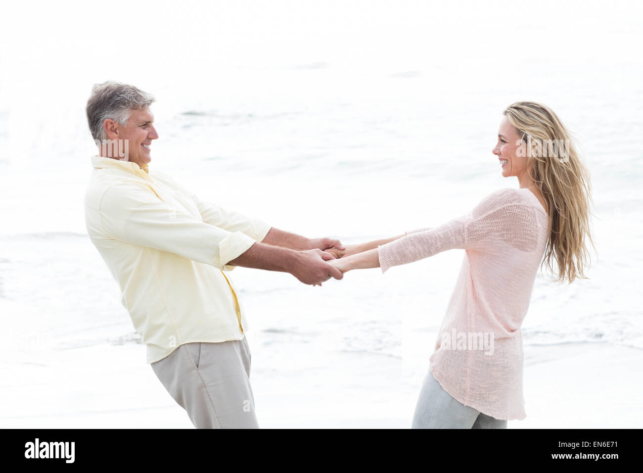 Happy couple holding hands and smiling at each other Stock Photo - Alamy