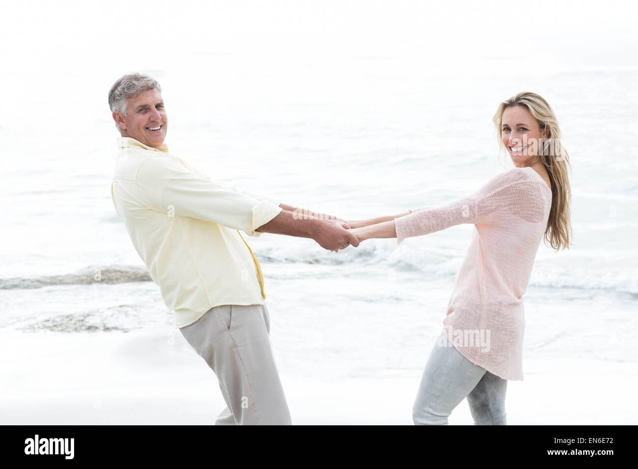Happy couple holding hands and smiling at camera Stock Photo - Alamy