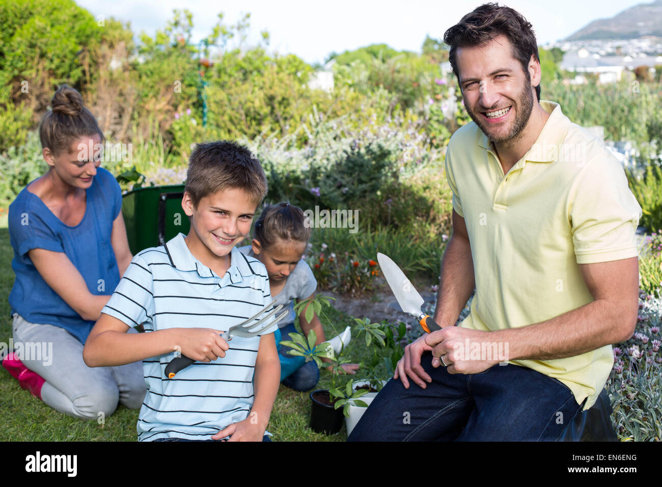 Happy young family gardening together Stock Photo
