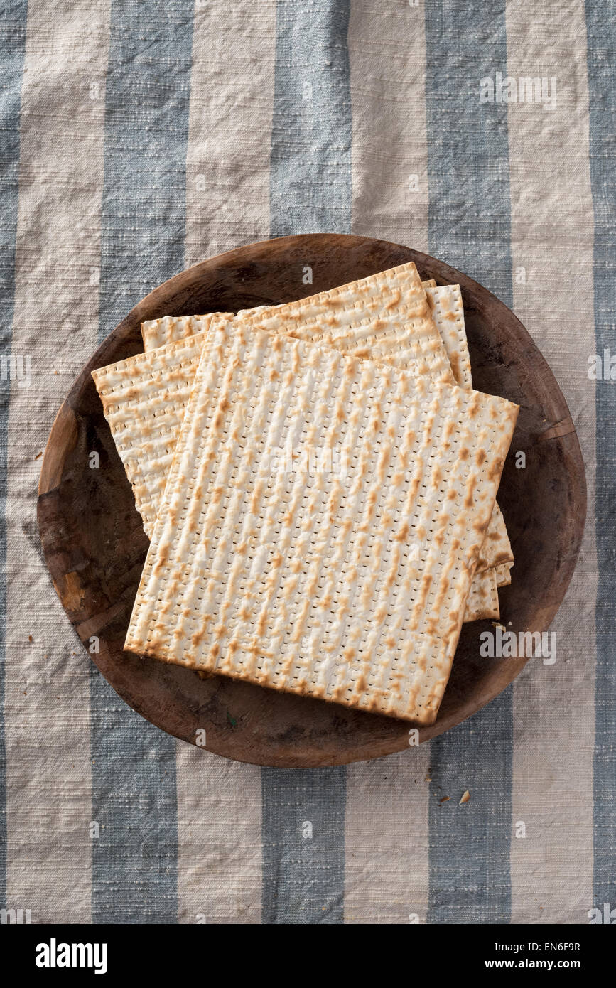 Matzah,  the unleavened bread used in the Jewish holiday passover, set on wood bowl in rustic setting Stock Photo