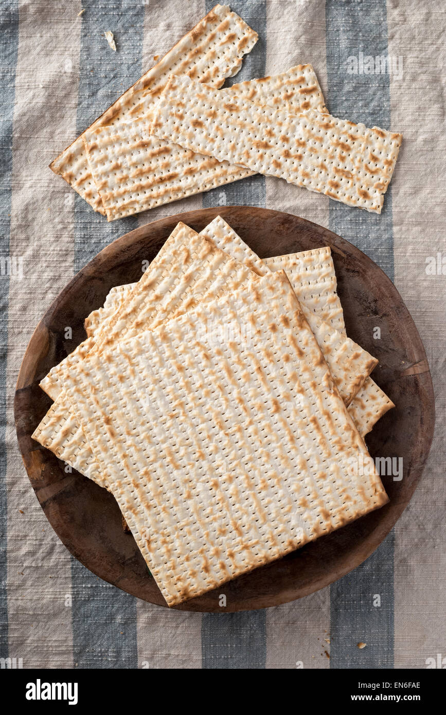 Matzah,  the unleavened bread used in the Jewish holiday passover, set on wood bowl in rustic setting Stock Photo