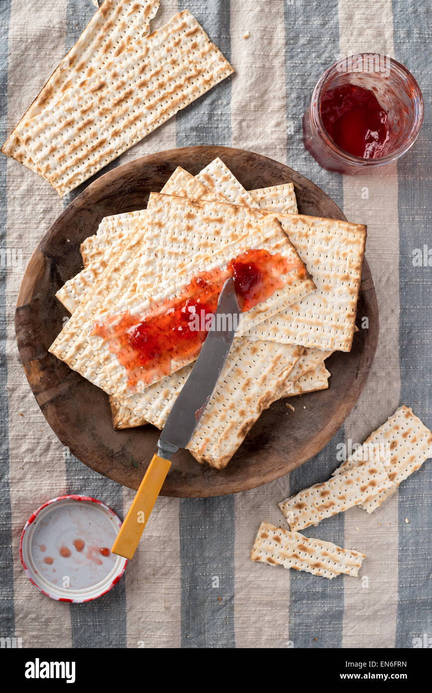 Matzah, served here with strawberry preserves,  the unleavened bread used in the Jewish holiday passover, set on wood bowl in ru Stock Photo