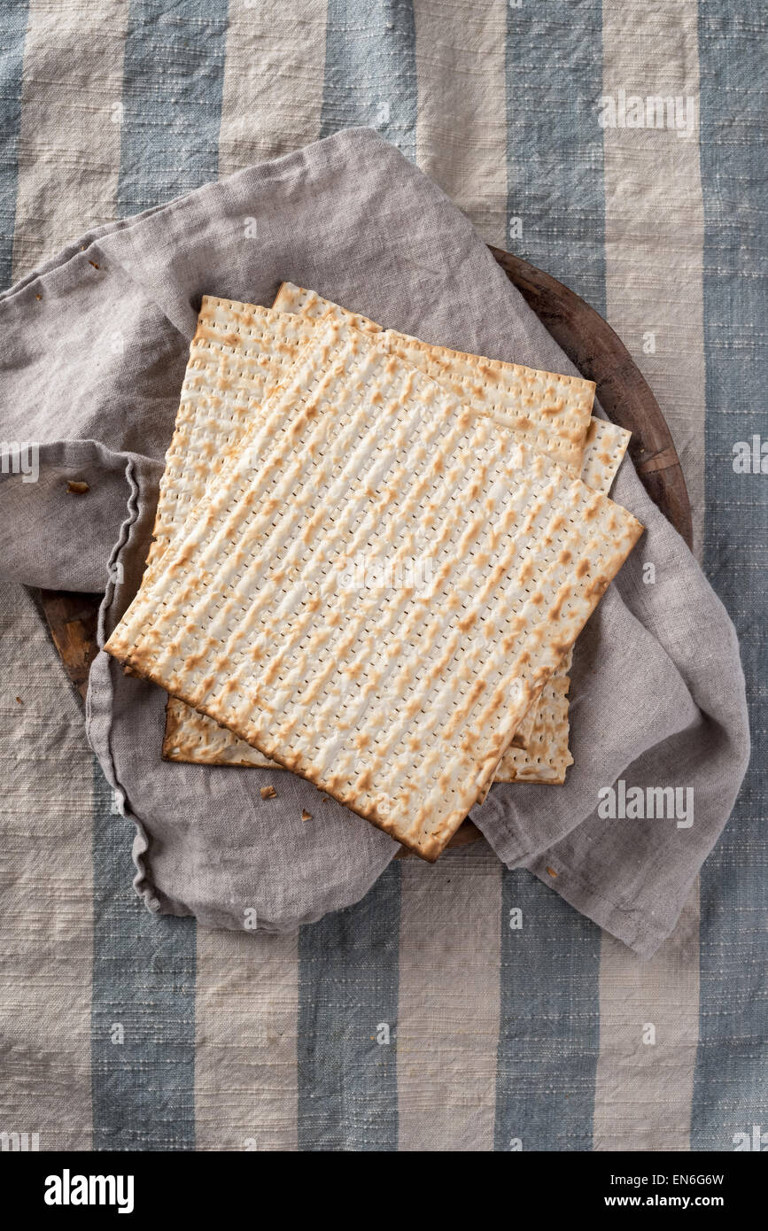 Matzah,  the unleavened bread used in the Jewish holiday passover, set on wood bowl in rustic setting Stock Photo