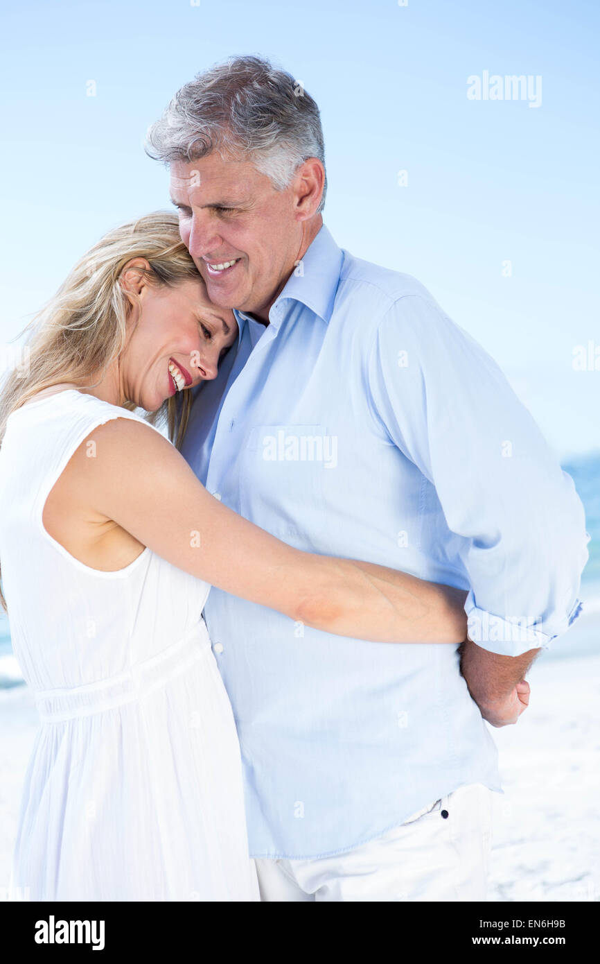 Happy couple standing by the sea and hugging each other Stock Photo - Alamy