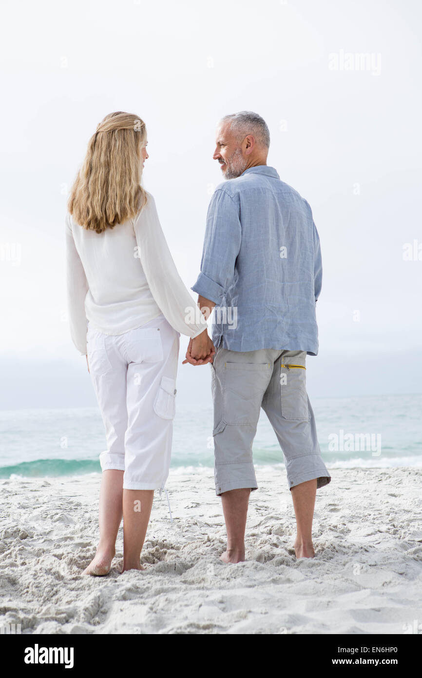 Happy couple holding hands and looking at each other Stock Photo - Alamy