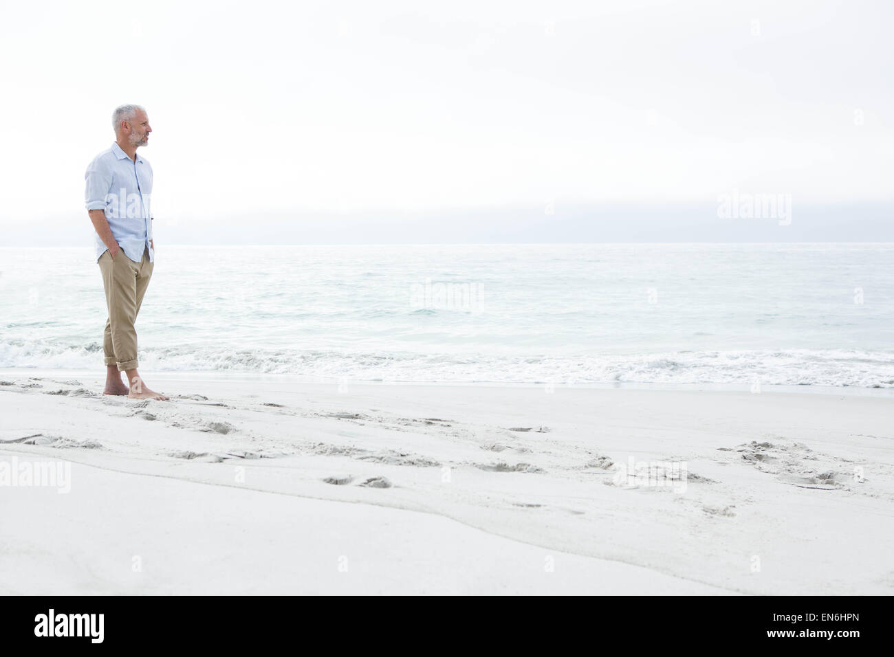 Thoughtful man standing by the sea Stock Photo - Alamy