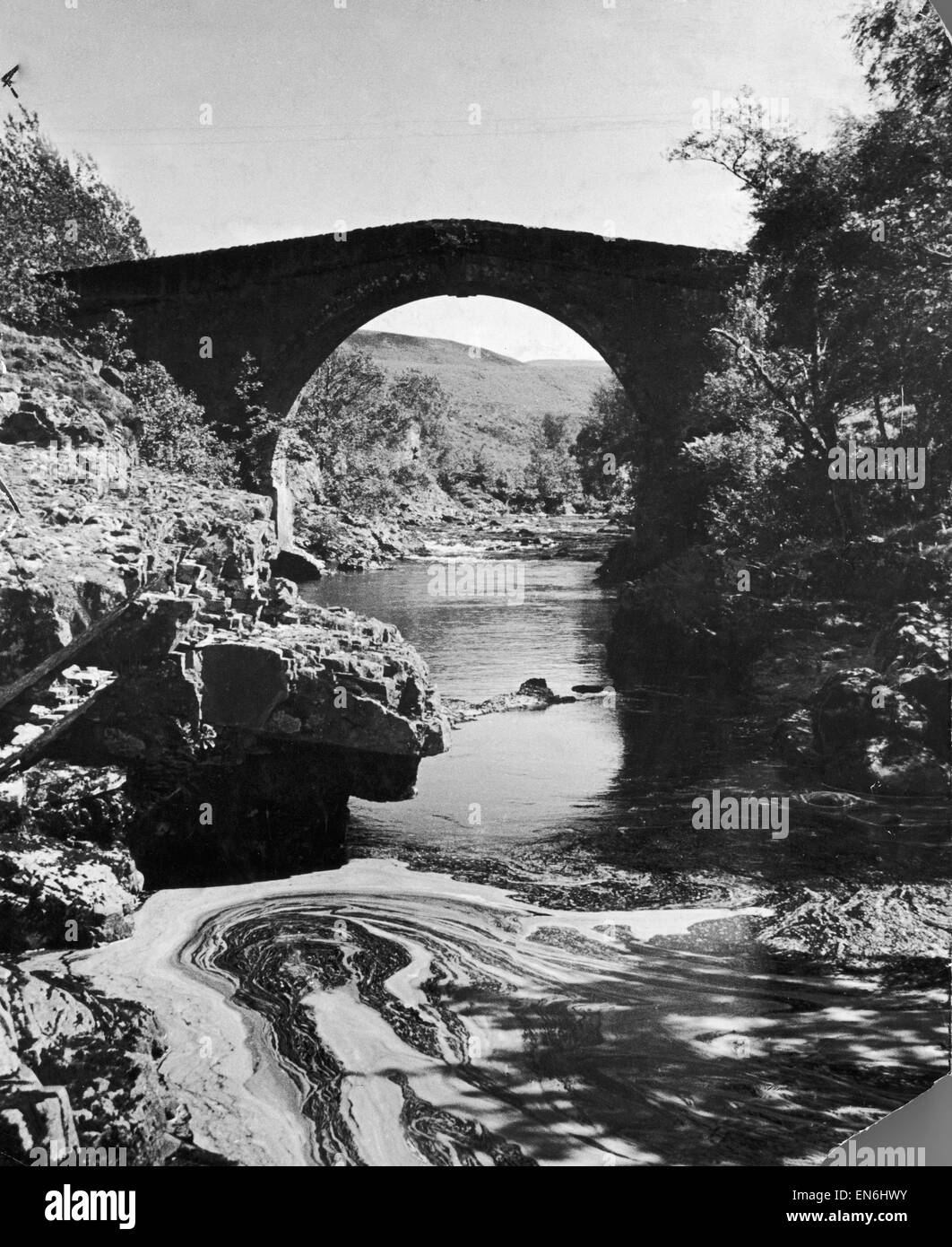 A stream passing underneath a stone bridge in rural Invernesshire, Scotland. July 1935. Stock Photo