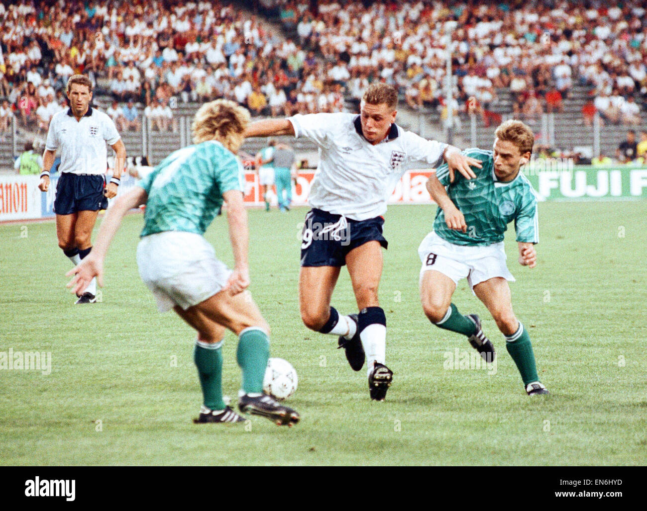 1990 World Cup Semi Final match the Stadio delle Alpi in Turin, Italy. West Germany 1 v England 1 (West Germany won on penalties). England's Paul Gascoigne is challenged for the ball by Andreas Brehme (left) and Thomas Haessler during the match. 4th July Stock Photo