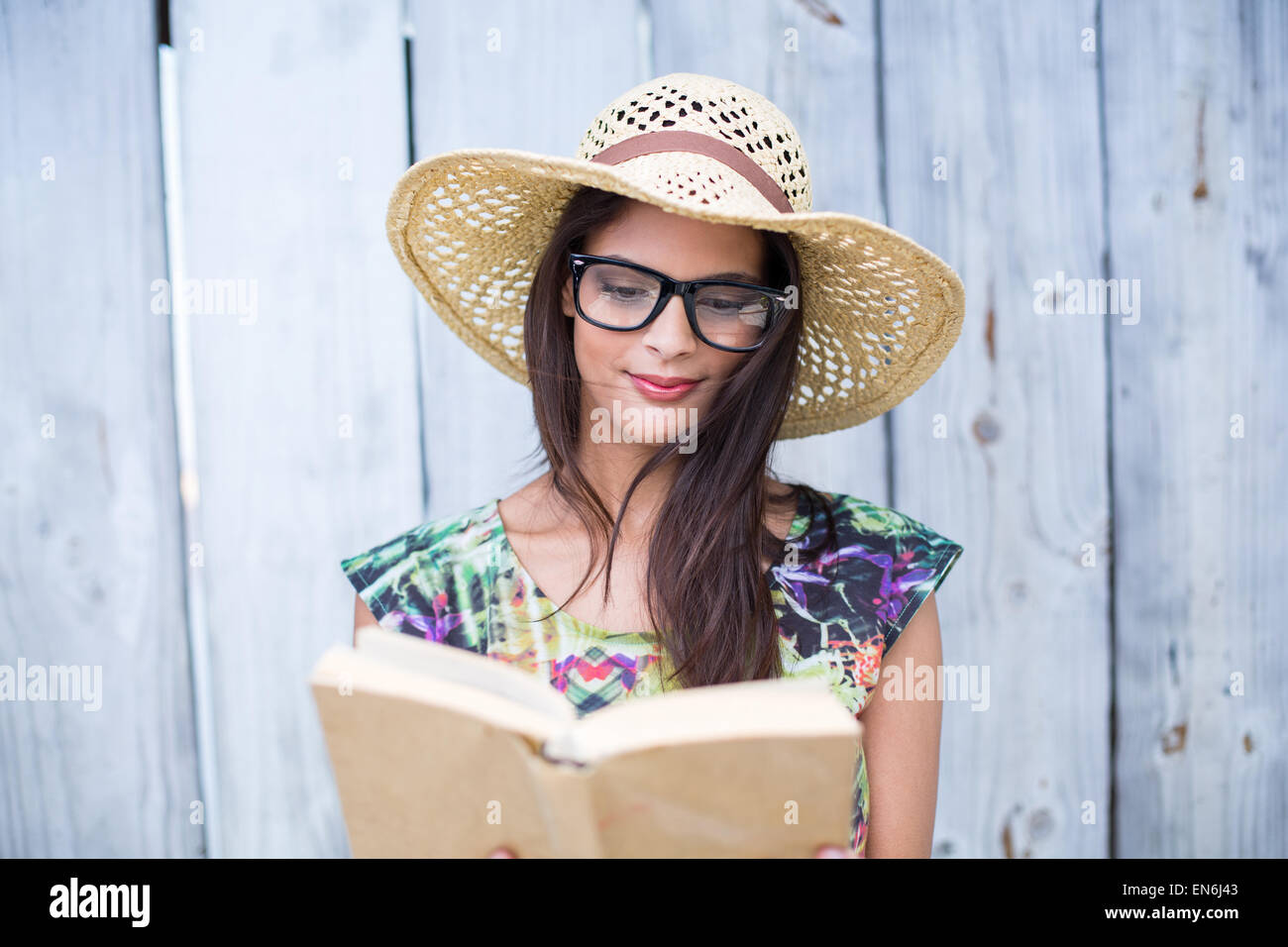 Smiling beautiful brunette reading a book Stock Photo
