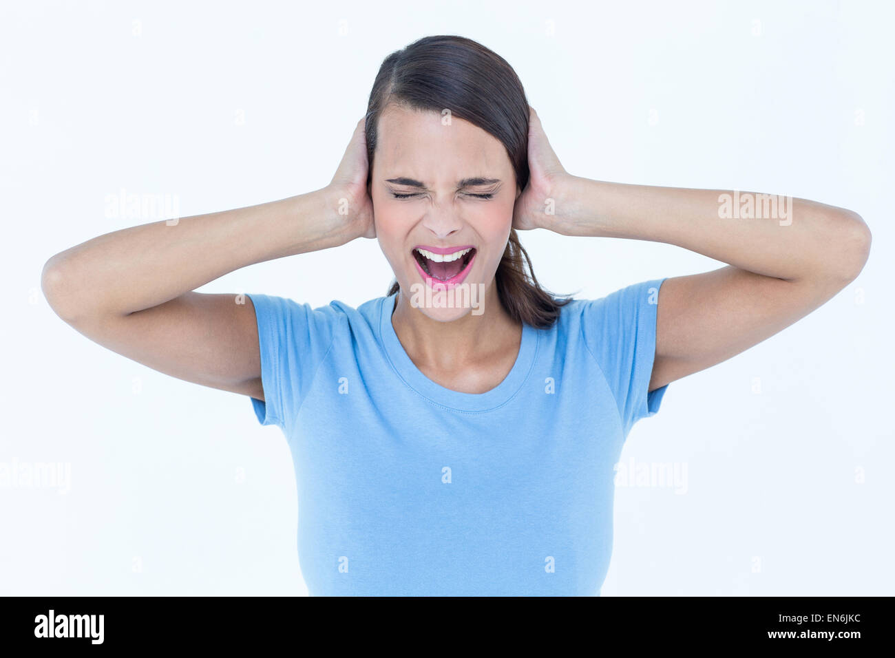 Screaming woman covering her ears Stock Photo