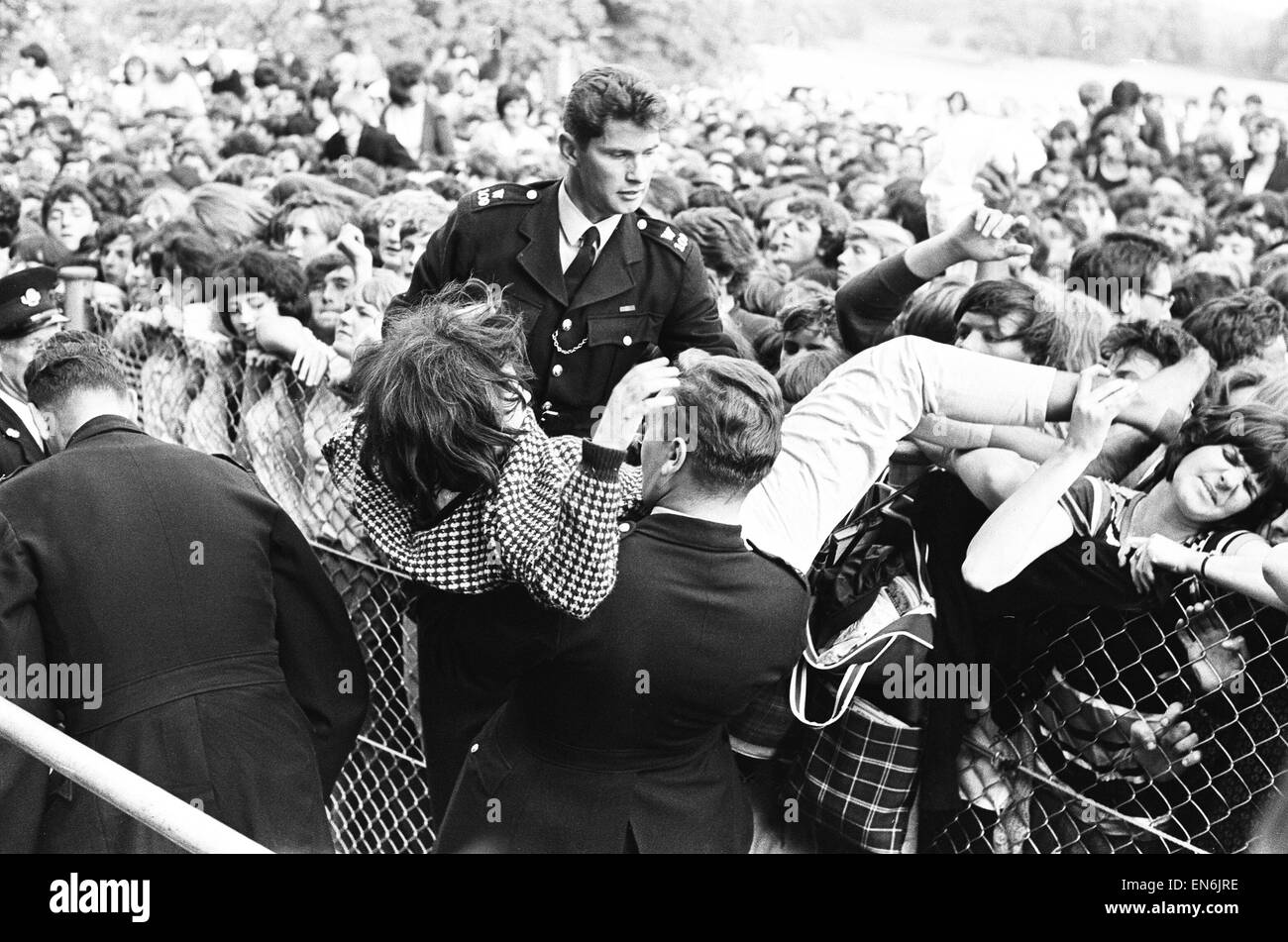 The Rolling Stones at Longleat, home of Lord Bath. Fainting girl fans are  carried off by the police. 2nd August 1964 Stock Photo - Alamy