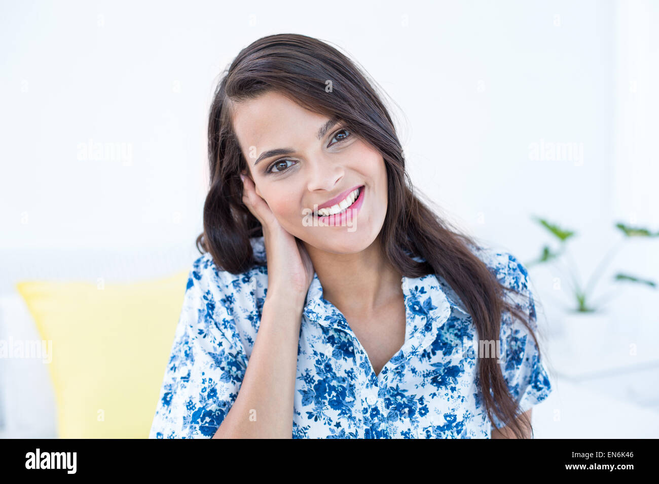 Beautiful woman smiling at camera sitting on her bed Stock Photo - Alamy