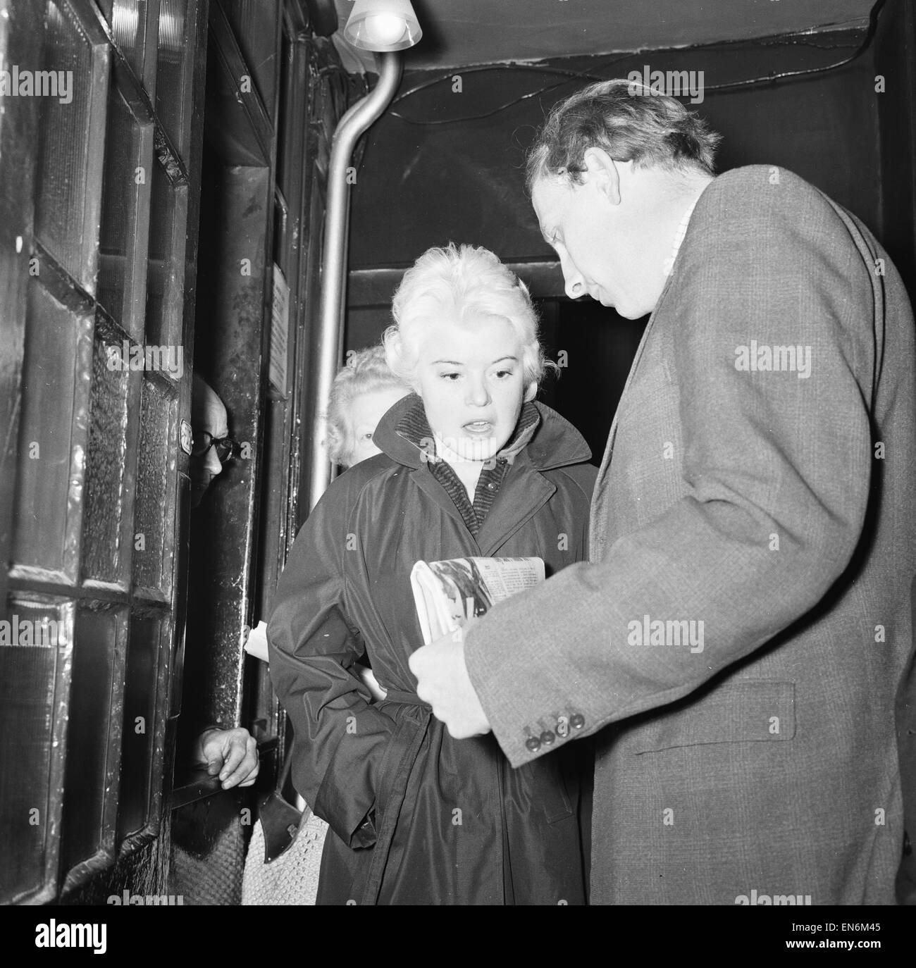 Peter Woods Daily Mirror Reporter showing singer Shani Wallis the story of her alleged rescue as she arrives at the Palace Theatre, Cambridge Circus for the show 'Fine Fettle' 23rd October 1959 Stock Photo