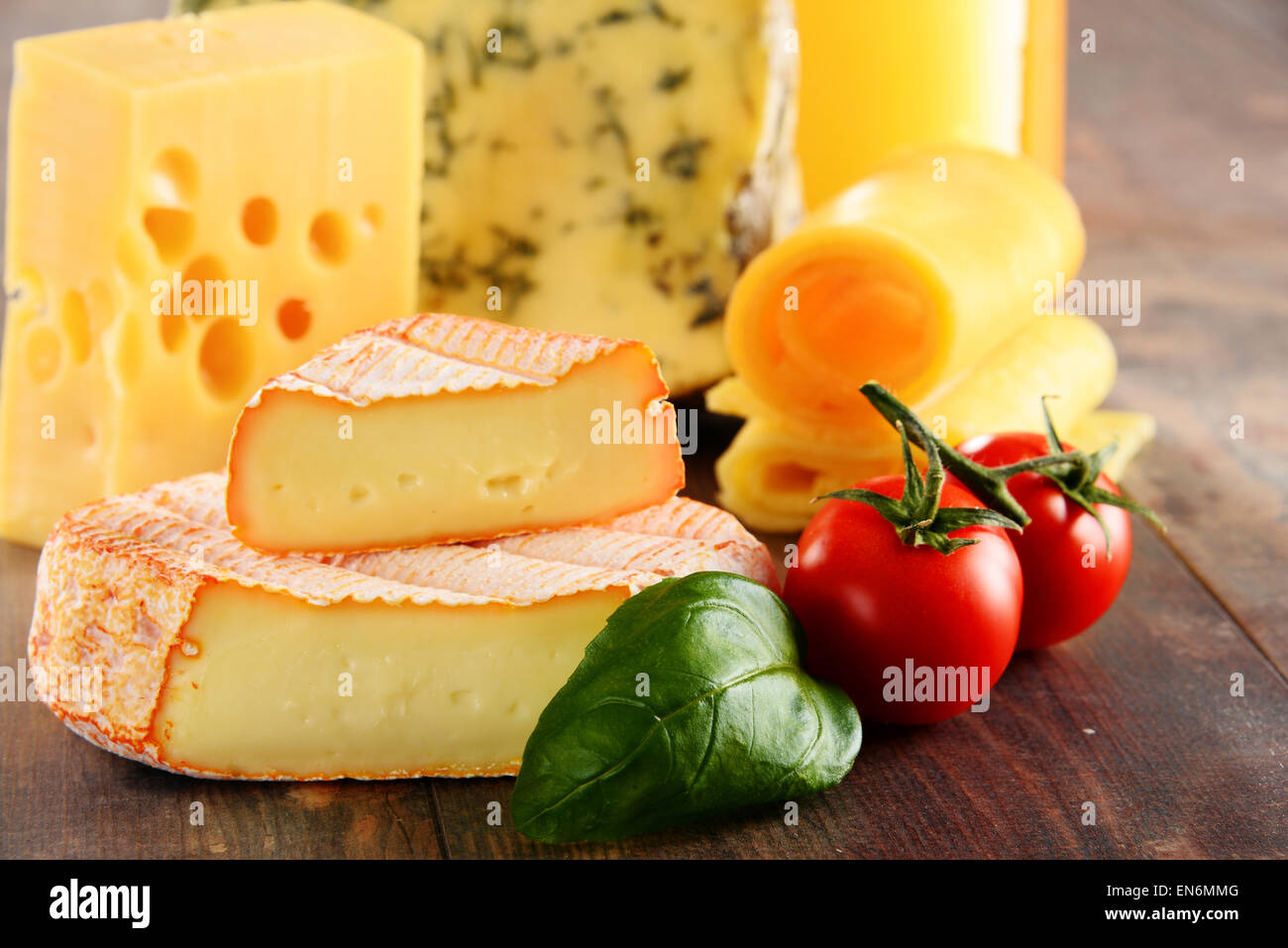Different sorts of cheese isolated on kitchen table Stock Photo - Alamy