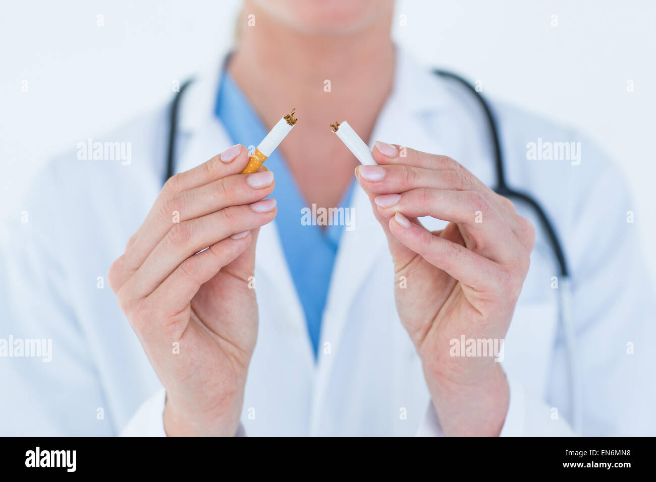 Doctor holding broken cigarette Stock Photo
