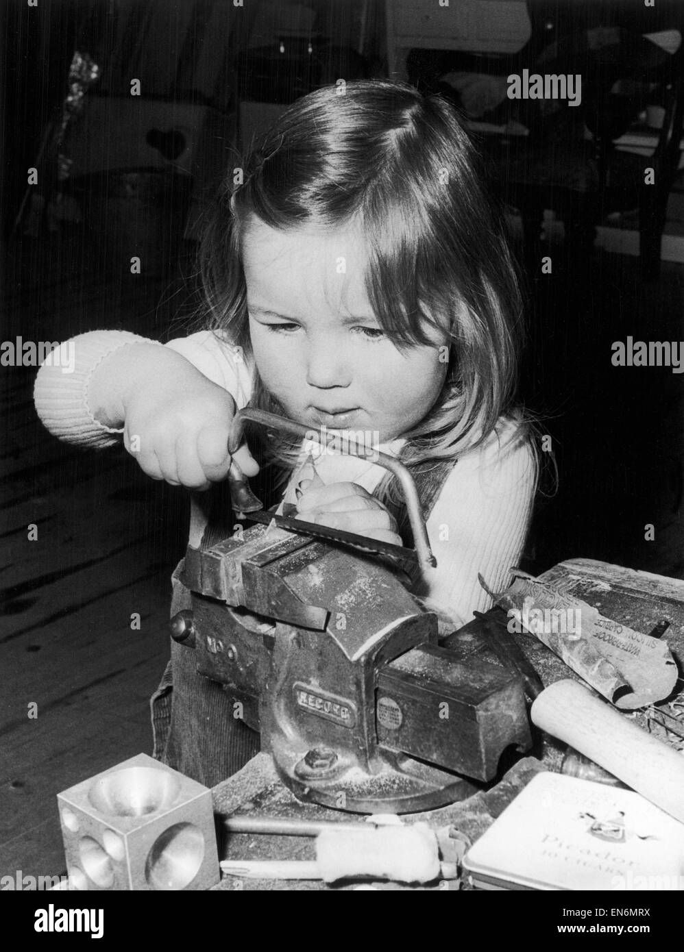 Three year old Pamela Murray working in her dad's Silversmiths workshop in Glenrothes, Scotland. September 1974 Stock Photo