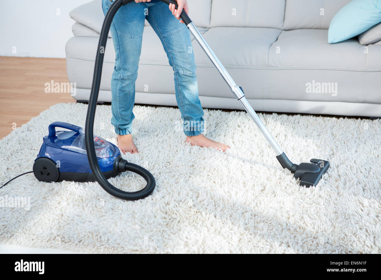 Woman using vacuum cleaner on carpet Stock Photo